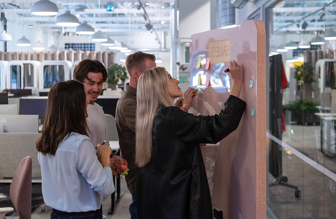 A group of people discussing in front of a whiteboard